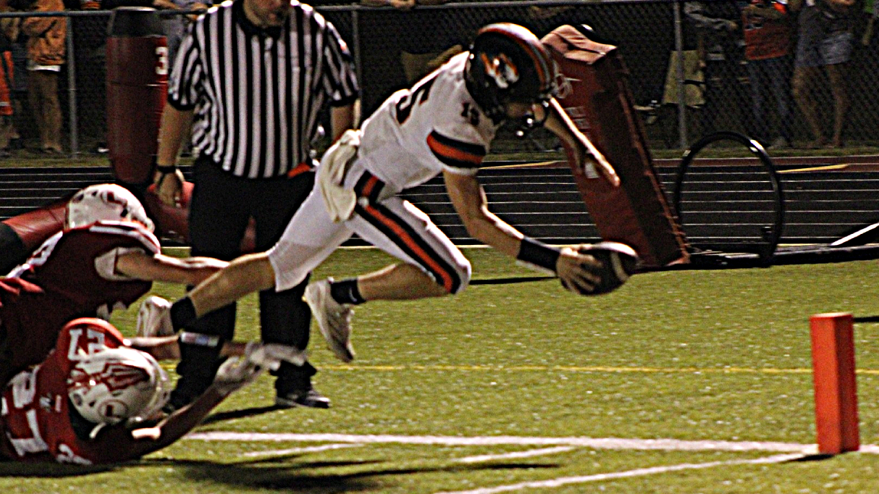 Olney's Gavyn Cothern dives across the goal line for a touchdown against Lawrenceville (Photo by Justin Hatten).