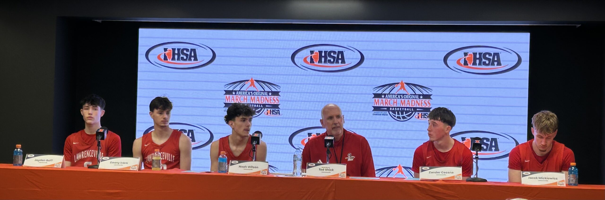 Lawrenceville coach Tad Shick (center) and players address the media after the Indians' loss to Goreville in the IHSA Class 1A semifinals on Thursday  Champaign (Photo by Josh Brown).